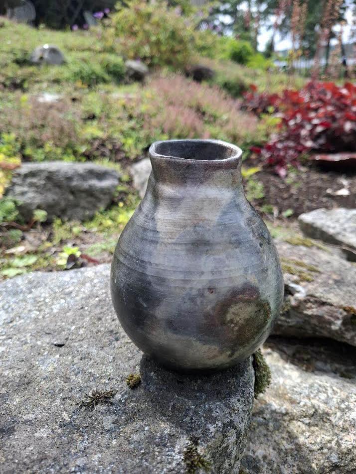 Liten glödugnsbränd kruka med mörk sotad yta